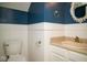 A powder room with two-toned walls, sink, mirror, and toilet at 7136 Allegan Dr, Indianapolis, IN 46217