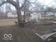 The backyard has a wooden deck, mature tree and detached garage with a privacy fence at 7240 W Glendale Ln, Greenfield, IN 46140