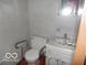 Small bathroom with a toilet with rails and a vanity with a marble countertop at 7240 W Glendale Ln, Greenfield, IN 46140