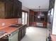 Retro kitchen with dark wood cabinets, vintage appliances and view to the dining room at 7240 W Glendale Ln, Greenfield, IN 46140