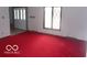 Bright living room with a large window with diamond panes and red carpet at 7240 W Glendale Ln, Greenfield, IN 46140
