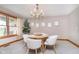 Bright dining room with white modern chairs, chandelier, and natural light from the window at 7260 N 225 W, Lebanon, IN 46052