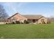Charming brick home with a well-manicured lawn, mature trees, and a welcoming front porch at 7260 N 225 W, Lebanon, IN 46052