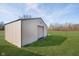 Metal outbuilding with light-colored door is surrounded by green grass under blue skies at 7260 N 225 W, Lebanon, IN 46052