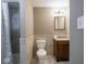 A clean bathroom features tile flooring, a single sink vanity, a toilet, and a tiled shower with a shower curtain at 7536 Shasta Dr, Indianapolis, IN 46217
