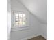 Cozy attic space with a charming window providing natural light and a glimpse of the outdoors at 766 N Bancroft St, Indianapolis, IN 46201