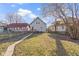 A spacious backyard featuring a well-maintained lawn and a charming gray house in a cozy neighborhood at 766 N Bancroft St, Indianapolis, IN 46201
