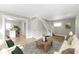 Bright living room featuring an open layout with a staircase and access to the kitchen, with hardwood flooring at 766 N Bancroft St, Indianapolis, IN 46201