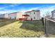 Backyard view of well-maintained lawn, fence, and red wooden deck with a bright orange pergola at 7939 Crackling Ln, Indianapolis, IN 46259
