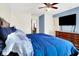 The bed, adorned with blue bedding, is complemented by a dresser and a wall-mounted TV at 7939 Crackling Ln, Indianapolis, IN 46259