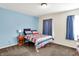 Bedroom with a bed, side table, and blue curtains providing a comfortable space at 7939 Crackling Ln, Indianapolis, IN 46259