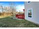 Exterior shot of a home's vinyl siding, yard, and red deck with bright orange pergola at 7939 Crackling Ln, Indianapolis, IN 46259