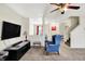 Spacious living room features a ceiling fan, neutral carpet, and an inviting blue chair at 7939 Crackling Ln, Indianapolis, IN 46259