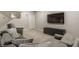 Basement living room with gray sectional sofa, a modern floor lamp, and a large flat screen TV at 804 Whispering Oaks Dr, Carmel, IN 46032