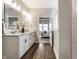 A bathroom showcasing a double vanity, wood floor, and view into the main bedroom at 804 Whispering Oaks Dr, Carmel, IN 46032