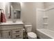 Bright bathroom with a white vanity cabinet, chrome hardware, framed mirror, and tub with shower combo at 804 Whispering Oaks Dr, Carmel, IN 46032