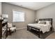 Bedroom with neutral walls and carpet features a metal bed frame, a chair, and a window at 804 Whispering Oaks Dr, Carmel, IN 46032