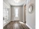 Entryway features wood floor, a front door with glass insert, and a decorative mirror on the right wall at 804 Whispering Oaks Dr, Carmel, IN 46032