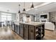 Kitchen island with a large sink, stone countertop, seating, and open shelving at 804 Whispering Oaks Dr, Carmel, IN 46032