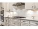 Well-lit kitchen featuring white cabinets, stainless steel appliances, and a modern gas cooktop at 804 Whispering Oaks Dr, Carmel, IN 46032