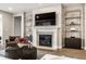 Cozy living room featuring a fireplace, a large TV, and stylish decor on shelves at 804 Whispering Oaks Dr, Carmel, IN 46032
