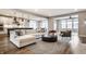 Bright and open living room with a modern sectional sofa, hardwood floors, and adjacent kitchen at 804 Whispering Oaks Dr, Carmel, IN 46032