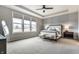 Spacious main bedroom features a large window, tray ceiling, ceiling fan, and accent wall at 804 Whispering Oaks Dr, Carmel, IN 46032