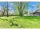 Backyard with a large, well-maintained lawn, mature trees, and a playset, perfect for Gathering fun and relaxation at 8190 Jordan Ln, Indianapolis, IN 46240