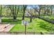 Spacious backyard with a basketball hoop, mature trees, and a playground, offering plenty of space for recreation at 8190 Jordan Ln, Indianapolis, IN 46240