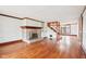 Bright living room featuring wood floors, a stone fireplace, and a staircase leading to the upper level at 8190 Jordan Ln, Indianapolis, IN 46240