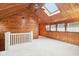Bright living room featuring wood-paneled walls, skylights, and a ceiling fan at 8190 Jordan Ln, Indianapolis, IN 46240