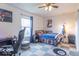 Cozy bedroom with unique ceiling fan, checkered carpet, gaming desk, and a single bed at 8444 Ash Grove Dr, Camby, IN 46113