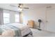 Bright bedroom features a ceiling fan, two large windows, and a wooden dresser at 8444 Ash Grove Dr, Camby, IN 46113