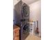 Laundry room features a stackable washer and dryer and a small shelving unit at 8444 Ash Grove Dr, Camby, IN 46113