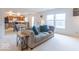 Spacious living room showcasing a plush sofa and seamless layout to the kitchen at 8444 Ash Grove Dr, Camby, IN 46113