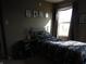 A cozy bedroom with a large window, decor, and neutral paint at 8848 Hosta Way, Camby, IN 46113