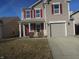 Charming two-story home featuring red door, red shutters, and a well-manicured lawn, and convenient attached garage at 8848 Hosta Way, Camby, IN 46113