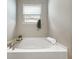 A relaxing white soaking tub features a bamboo caddy and a window for a spa-like bathroom experience at 9034 Faulkner Dr, Indianapolis, IN 46239
