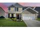 Charming two-story home with brick accents, a manicured lawn, and a two-car garage at 9034 Faulkner Dr, Indianapolis, IN 46239