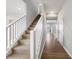 Carpeted stairs with white railing lead to the second floor, with light hardwood flooring at 9034 Faulkner Dr, Indianapolis, IN 46239