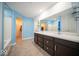 Bright bathroom with double vanity, a large mirror, and a separate toilet room, enhanced by soothing blue walls at 10202 Meadow Path Ln, Indianapolis, IN 46239