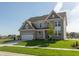 Beautiful two-story home with brick and siding, attached garage, green lawn and tree at 1101 Knoll Ct, Greenwood, IN 46143