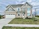 Charming two-story home featuring a gray brick facade, attached two-car garage and a well-manicured lawn at 1101 Knoll Ct, Greenwood, IN 46143
