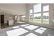 Spacious open-concept living room featuring large windows and views of the backyard at 1101 Knoll Ct, Greenwood, IN 46143