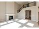Open-concept living area with fireplace and staircase featuring a black banister at 1101 Knoll Ct, Greenwood, IN 46143