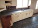 Kitchen with dated cabinets, laminate countertops, and a stainless steel sink at 1133 N Livingston Ave, Indianapolis, IN 46222