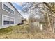 View of the backyard with the deck, gray siding, sparse grass, and a partially-fenced yard at 11410 Dunshire Dr, Indianapolis, IN 46229