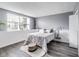 Bedroom featuring a bed with white bedding, bright window, and hardwood flooring at 11410 Dunshire Dr, Indianapolis, IN 46229
