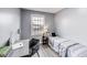 Bedroom with grey walls, wood floors, a desk, and a bright window view at 11410 Dunshire Dr, Indianapolis, IN 46229