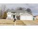 Traditional two-story home featuring gray siding and a spacious two-car garage on a sunny day at 11410 Dunshire Dr, Indianapolis, IN 46229